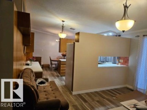 Living room featuring ornamental molding and wood finished floors - 4910 53 Avenue, Willingdon, AB 