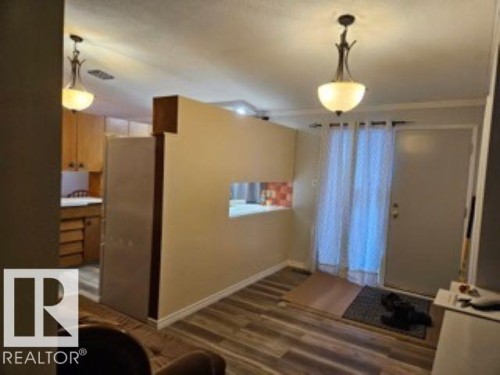 Entryway with baseboards and dark wood-type flooring - 4910 53 Avenue, Willingdon, AB 
