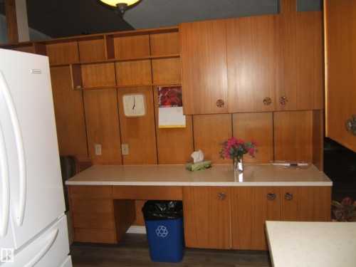 Kitchen with freestanding refrigerator and brown cabinetry - 4910 53 Avenue, Willingdon, AB 