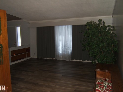 Unfurnished living room with dark wood-type flooring - 4910 53 Avenue, Willingdon, AB 