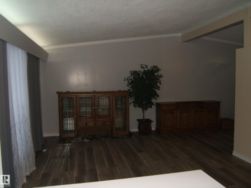 Foyer entrance with dark wood-style flooring and crown molding - 4910 53 Avenue, Willingdon, AB 