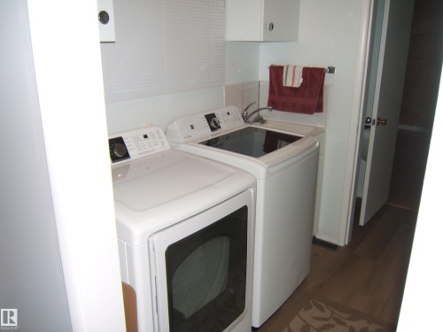 Washroom featuring dark wood-style flooring and separate washer and dryer - 4910 53 Avenue, Willingdon, AB 