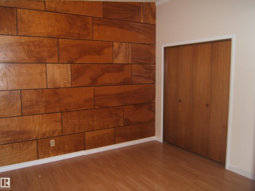 Unfurnished bedroom featuring wood finished floors and a closet - 4910 53 Avenue, Willingdon, AB 
