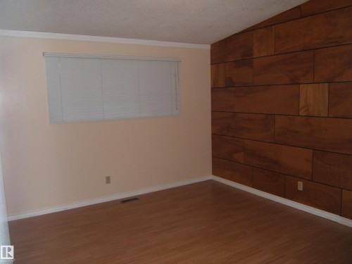 Spare room with wood finished floors and crown molding - 4910 53 Avenue, Willingdon, AB 