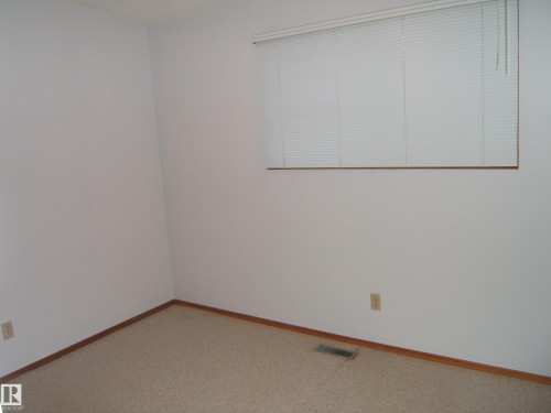 Carpeted spare room featuring baseboards - 4910 53 Avenue, Willingdon, AB 