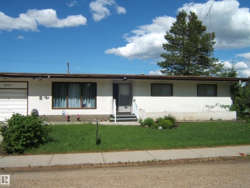 Single-story residence featuring a white stucco exterior and a brown roofline - 4910 53 Avenue, Willingdon, AB 