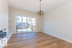 Unfurnished dining area with light wood-type flooring, a chandelier, and a glass covered fireplace - 