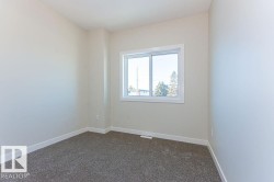Empty room with dark colored carpet and baseboards - 