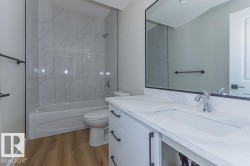Bathroom with washtub / shower combination, vanity, and light wood-type flooring - 