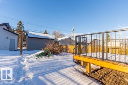 Snowy yard with a wooden deck and an outbuilding - 