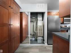 Kitchen featuring stainless steel appliances, dark countertops, light wood-style flooring, brown cabinets, and heating unit - 