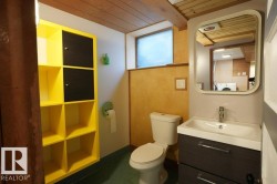 Bathroom with a wooden ceiling with exposed beams, vanity, and washer / dryer - 