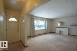 Entryway with light colored carpet and a textured ceiling - 