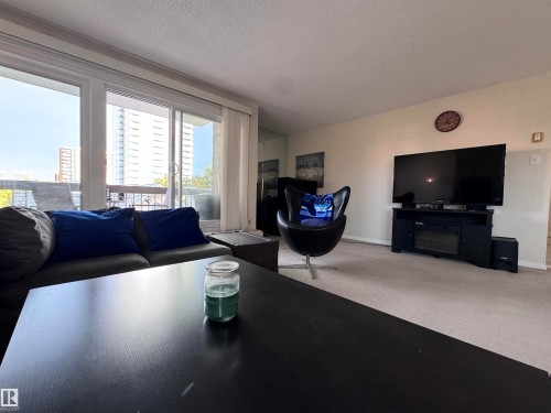 Carpeted living room with a textured ceiling and baseboards - 503 9737 112 Street, Edmonton, AB - Indoor Photo Showing Living Room