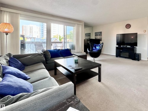 Living room with carpet floors and a textured ceiling - 503 9737 112 Street, Edmonton, AB - Indoor Photo Showing Living Room