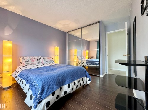 Bedroom featuring dark wood-style flooring, a closet, and a textured ceiling - 503 9737 112 Street, Edmonton, AB - Indoor Photo Showing Bedroom