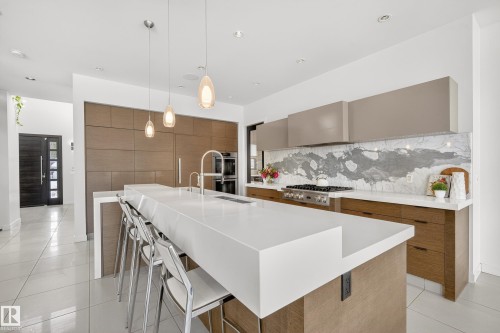 Kitchen featuring modern cabinets, tasteful backsplash, decorative light fixtures, a kitchen breakfast bar, and recessed lighting - 9415 144 Street, Edmonton, AB - Indoor Photo Showing Kitchen With Upgraded Kitchen