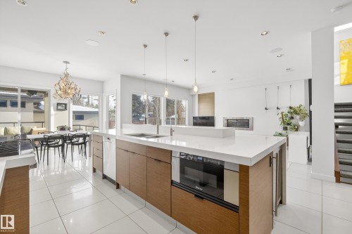 Kitchen featuring modern cabinets, decorative light fixtures, a large island, recessed lighting, and light tile patterned floors - 9415 144 Street, Edmonton, AB - Indoor Photo Showing Kitchen With Double Sink With Upgraded Kitchen