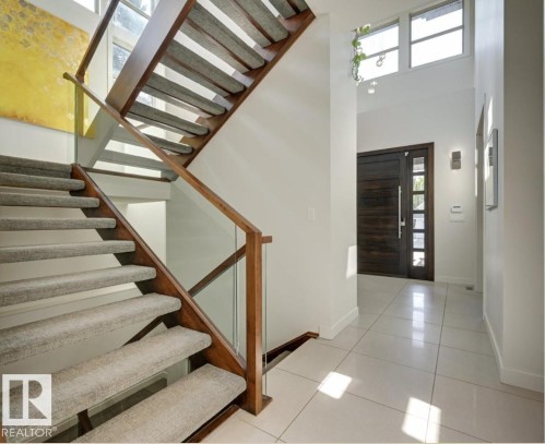 Foyer entrance with a high ceiling, light tile patterned floors, and stairs - 9415 144 Street, Edmonton, AB - Indoor Photo Showing Other Room