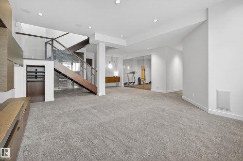 Unfurnished living room with stairs, light carpet, and recessed lighting - 9415 144 Street, Edmonton, AB - Indoor Photo Showing Other Room