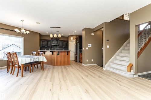 Kitchen with a breakfast bar, light wood finished floors, a chandelier, recessed lighting, and high end fridge - 1612 Lacombe Crest, Edmonton, AB - Indoor Photo Showing Dining Room