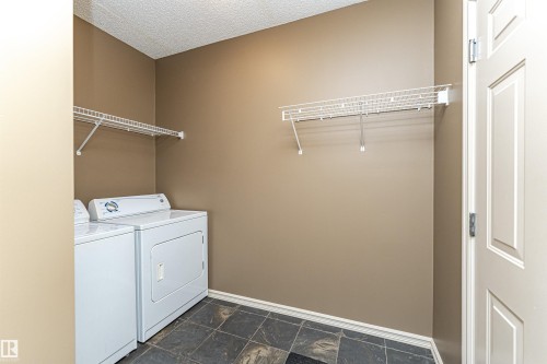 Washroom featuring washer and clothes dryer and a textured ceiling - 1612 Lacombe Crest, Edmonton, AB - Indoor Photo Showing Laundry Room