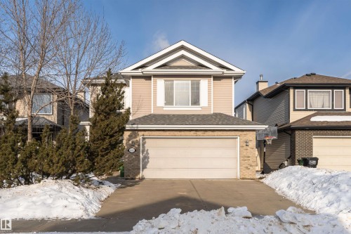 View of front of property featuring brick siding, a garage, driveway, and roof with shingles - 1612 Lacombe Crest, Edmonton, AB - Outdoor