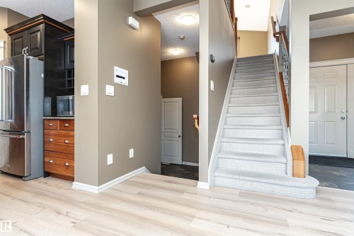 Staircase featuring a textured ceiling and wood finished floors - 1612 Lacombe Crest, Edmonton, AB - Indoor Photo Showing Other Room