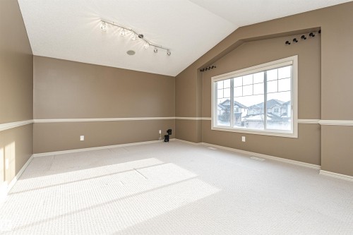 Carpeted spare room featuring lofted ceiling and track lighting - 1612 Lacombe Crest, Edmonton, AB - Indoor Photo Showing Other Room