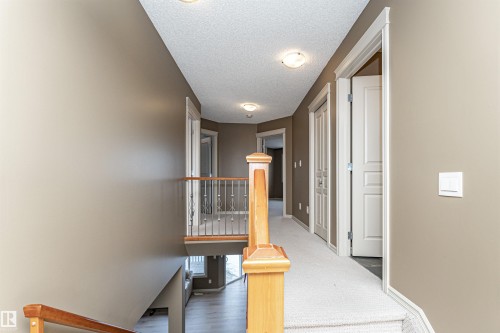Hallway featuring a textured ceiling and an upstairs landing - 1612 Lacombe Crest, Edmonton, AB - Indoor Photo Showing Other Room