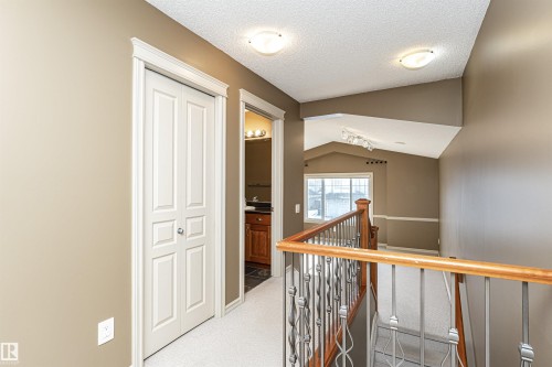 Hallway featuring vaulted ceiling, an upstairs landing, a textured ceiling, and carpet flooring - 1612 Lacombe Crest, Edmonton, AB - Indoor Photo Showing Other Room