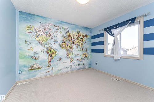 Carpeted spare room with a textured ceiling and an accent wall - 1612 Lacombe Crest, Edmonton, AB - Indoor Photo Showing Other Room