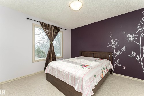 Carpeted bedroom with a textured ceiling and an accent wall - 1612 Lacombe Crest, Edmonton, AB - Indoor Photo Showing Bedroom