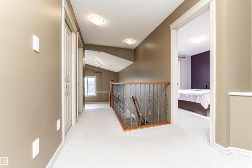 Corridor with lofted ceiling, carpet flooring, an upstairs landing, and a textured ceiling - 1612 Lacombe Crest, Edmonton, AB - Indoor Photo Showing Other Room