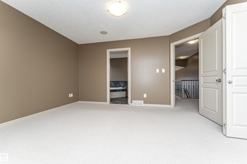 Empty room with light colored carpet and a textured ceiling - 1612 Lacombe Crest, Edmonton, AB - Indoor Photo Showing Other Room