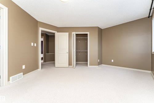 Unfurnished bedroom featuring carpet flooring, a closet, and a textured ceiling - 1612 Lacombe Crest, Edmonton, AB - Indoor Photo Showing Other Room