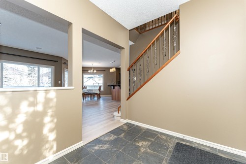 Entryway with a chandelier, dark stone finish floors, stairs, and a textured ceiling - 1612 Lacombe Crest, Edmonton, AB - Indoor Photo Showing Other Room