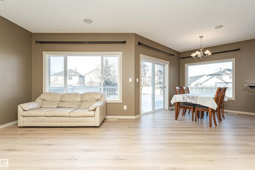 Dining area with light wood-style flooring, a chandelier, and a textured ceiling - 1612 Lacombe Crest, Edmonton, AB - Indoor Photo Showing Living Room