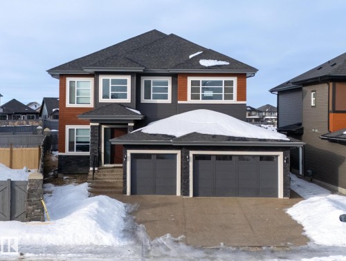 View of front of property featuring a residential view, roof with shingles, driveway, and a garage - 3904 Ginsburg Crescent, Edmonton, AB - Outdoor With Facade