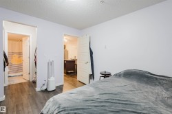 Bedroom featuring dark wood-style flooring, a textured ceiling, and connected bathroom - 