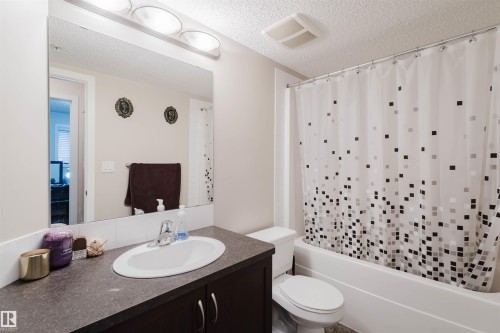 Bathroom with vanity, shower / bath combo, and a textured ceiling - 108 396 Silver Berry Road, Edmonton, AB - Indoor Photo Showing Bathroom