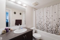 Bathroom with vanity, shower / bath combo, and a textured ceiling - 