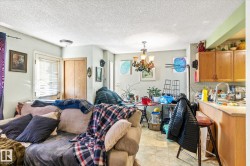 Living room featuring a textured ceiling, healthy amount of natural light, a chandelier, and light tile patterned floors - 