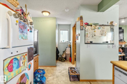 Kitchen with freestanding refrigerator and a textured ceiling - 15035 133 Street, Edmonton, AB - Indoor
