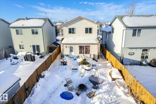 Snow covered rear of property featuring a residential view, a fenced backyard, and a patio - 15035 133 Street, Edmonton, AB - Outdoor