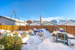 Yard layered in snow with a fenced backyard and a residential view - 