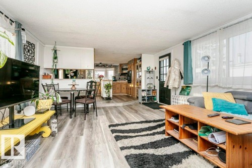 Living room featuring light wood-style flooring, a textured ceiling, and crown molding - 216 53222 Rge Rd 272, Rural Parkland County, AB - Indoor