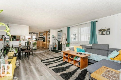 Living room featuring plenty of natural light, light wood finished floors, a textured ceiling, and ornamental molding - 216 53222 Rge Rd 272, Rural Parkland County, AB - Indoor Photo Showing Living Room