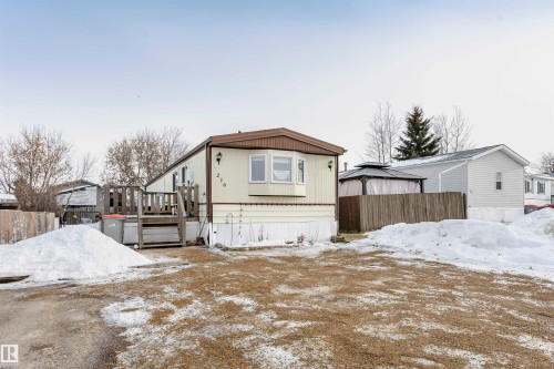 Snow covered rear of property with a deck - 216 53222 Rge Rd 272, Rural Parkland County, AB - Outdoor