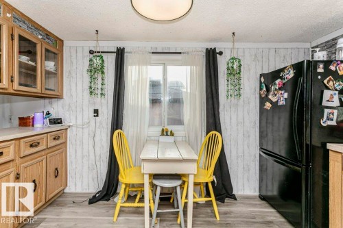 Dining area featuring light wood-type flooring, wooden walls, and a textured ceiling - 216 53222 Rge Rd 272, Rural Parkland County, AB - Indoor Photo Showing Dining Room